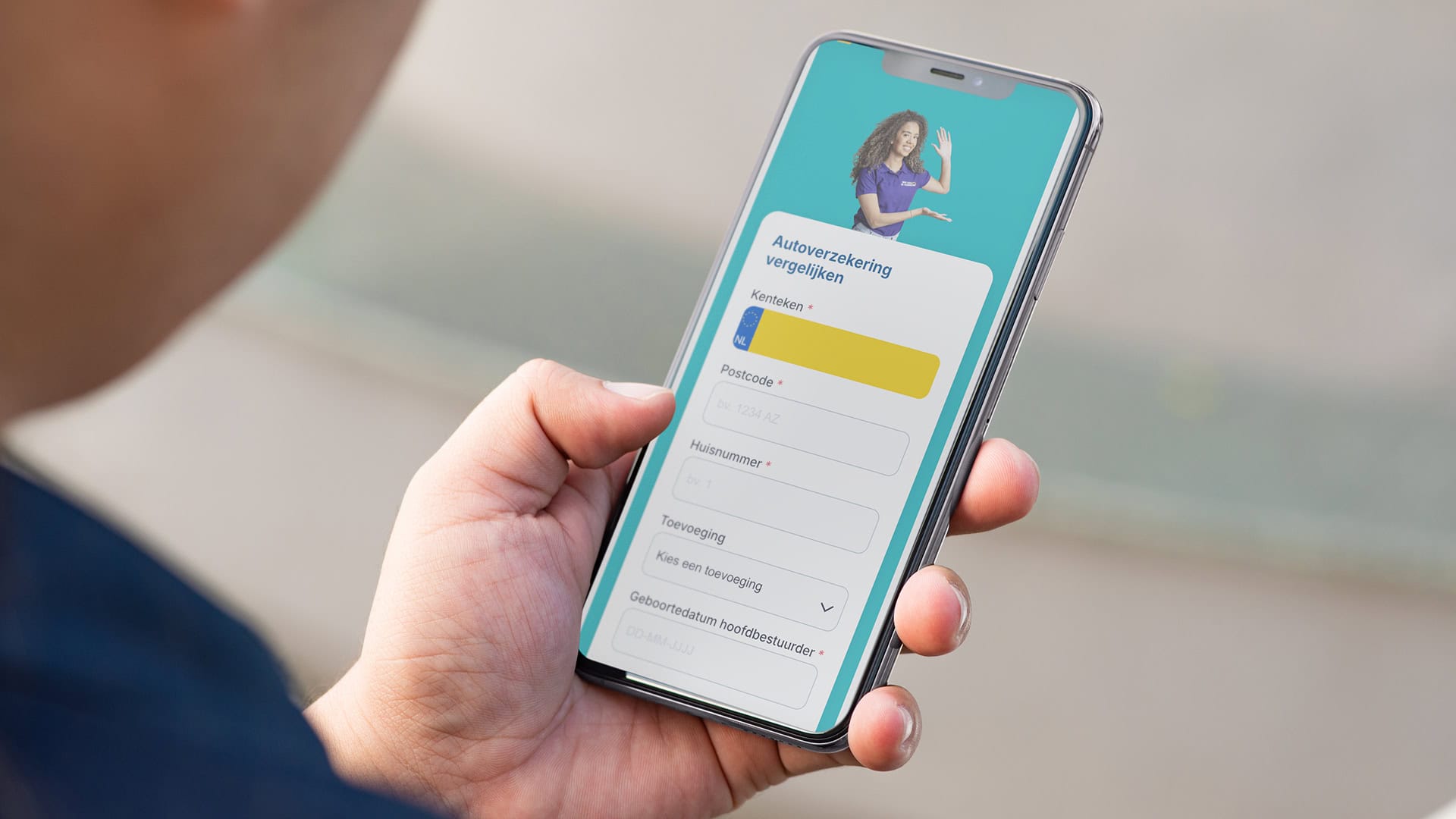 Man met telefoon in zijn hand om een auto verzekering te berekenen